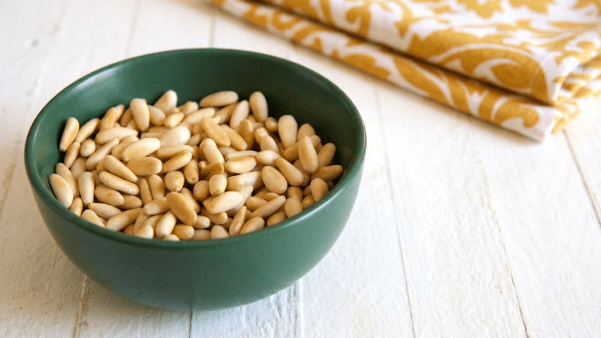 bowl of pine nuts in a small wooden bowl ready for cooking