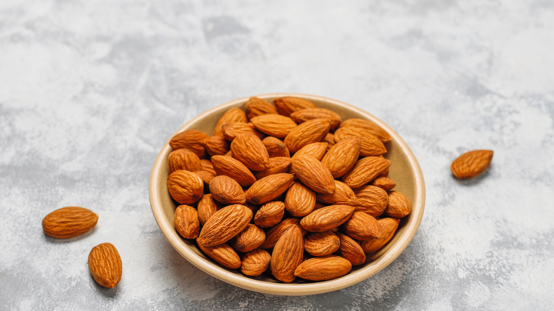 bowl of raw almonds showing a nutritious low calorie nut for snacks breakfast and recipes