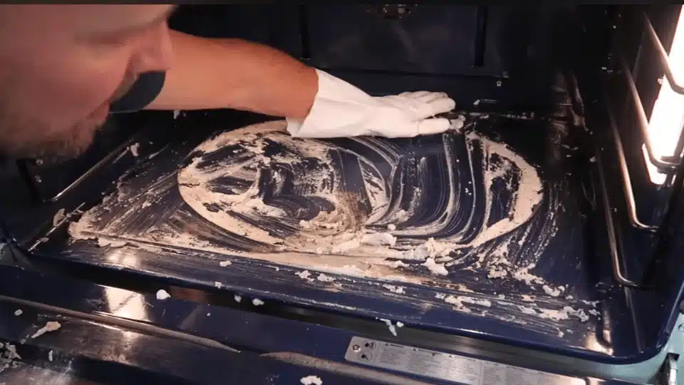 a person with a soft sponge scrubbing inside of the pan (2)