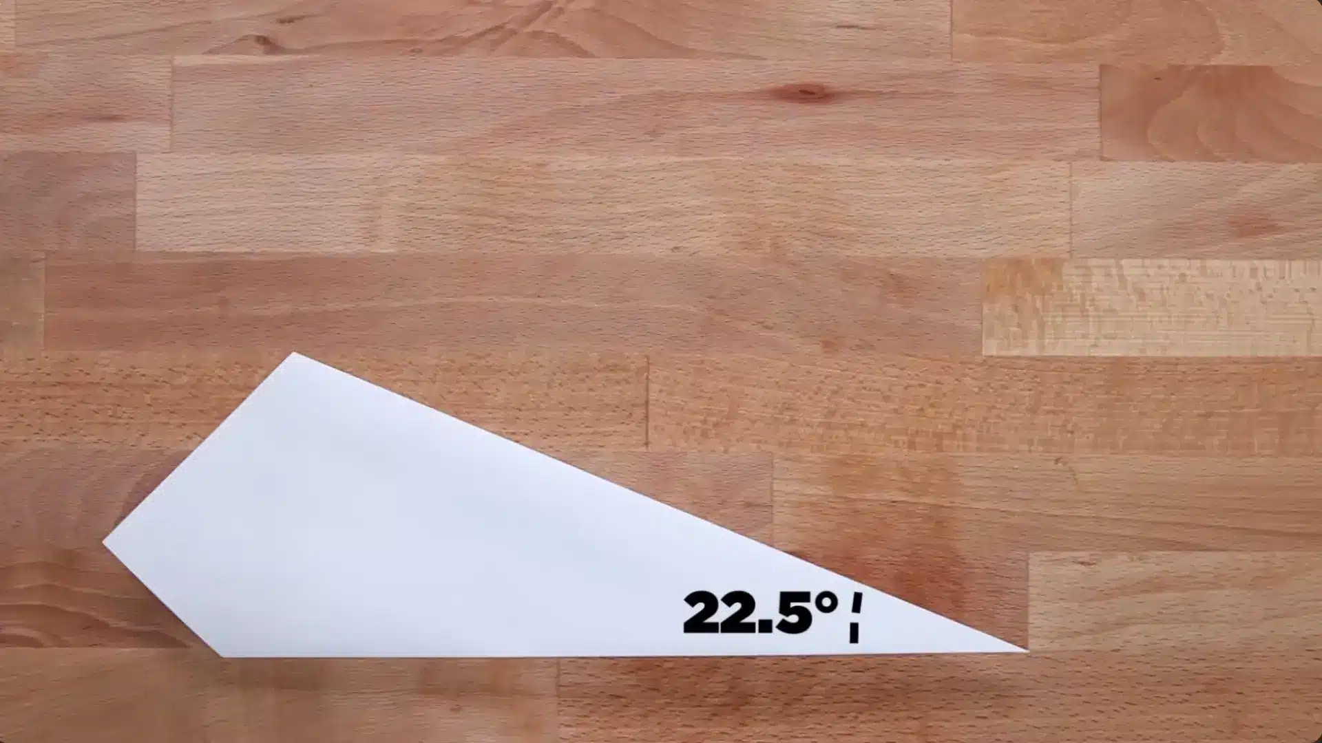 a white paper wedge on a wooden surface illustrates a angle for precision knife sharpening