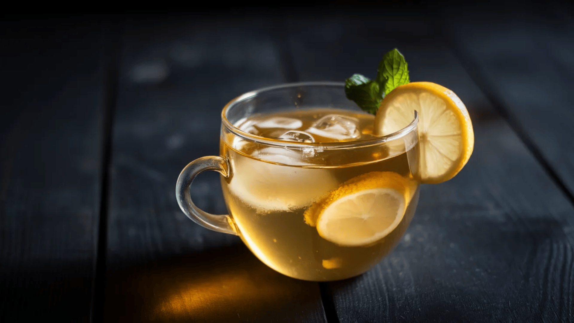 green tea in a clear glass cup, centered with dramatic side lighting on a dark moody background