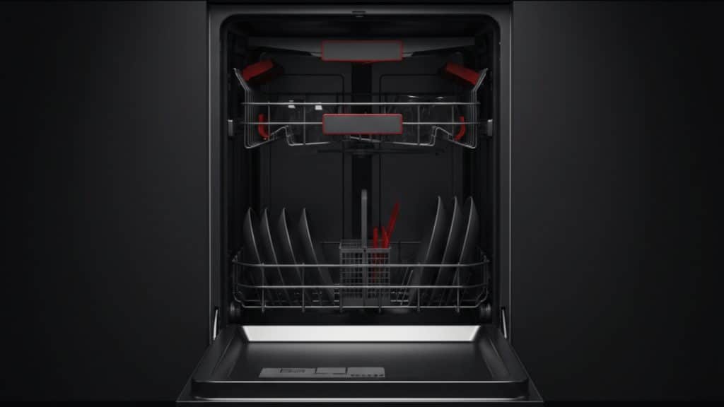 open stainless steel dishwasher in dark kitchen with red interior accents and plates on lower rack