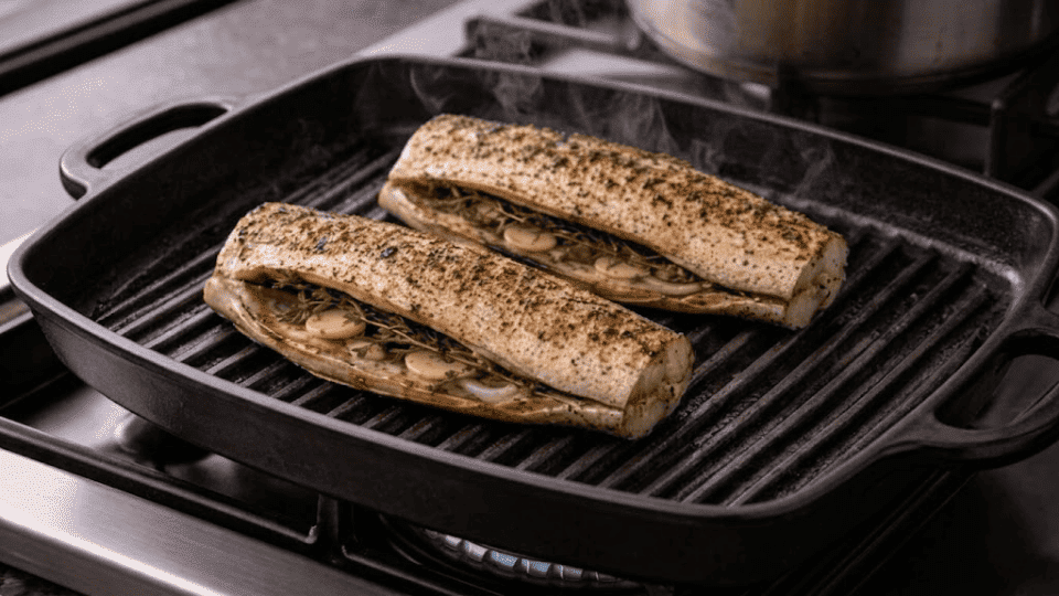 trout cavity with garlic cloves and herbs getting grille