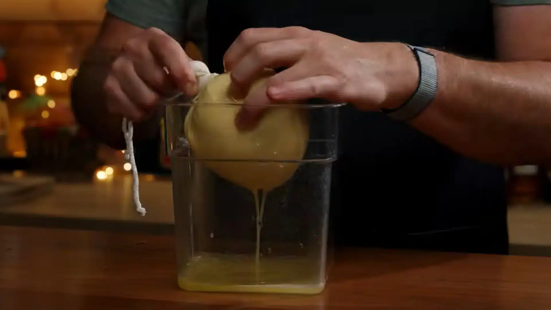 blended pineapple pulp being strained through a fine mesh bag to extract smooth fresh juice