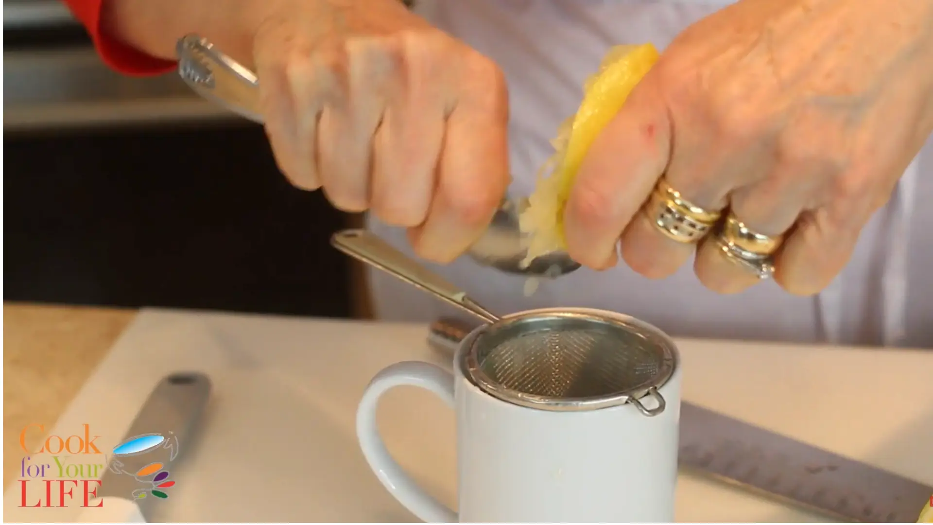 fresh lemon being squeezed into a cup to extract juice for homemade lemon drink
