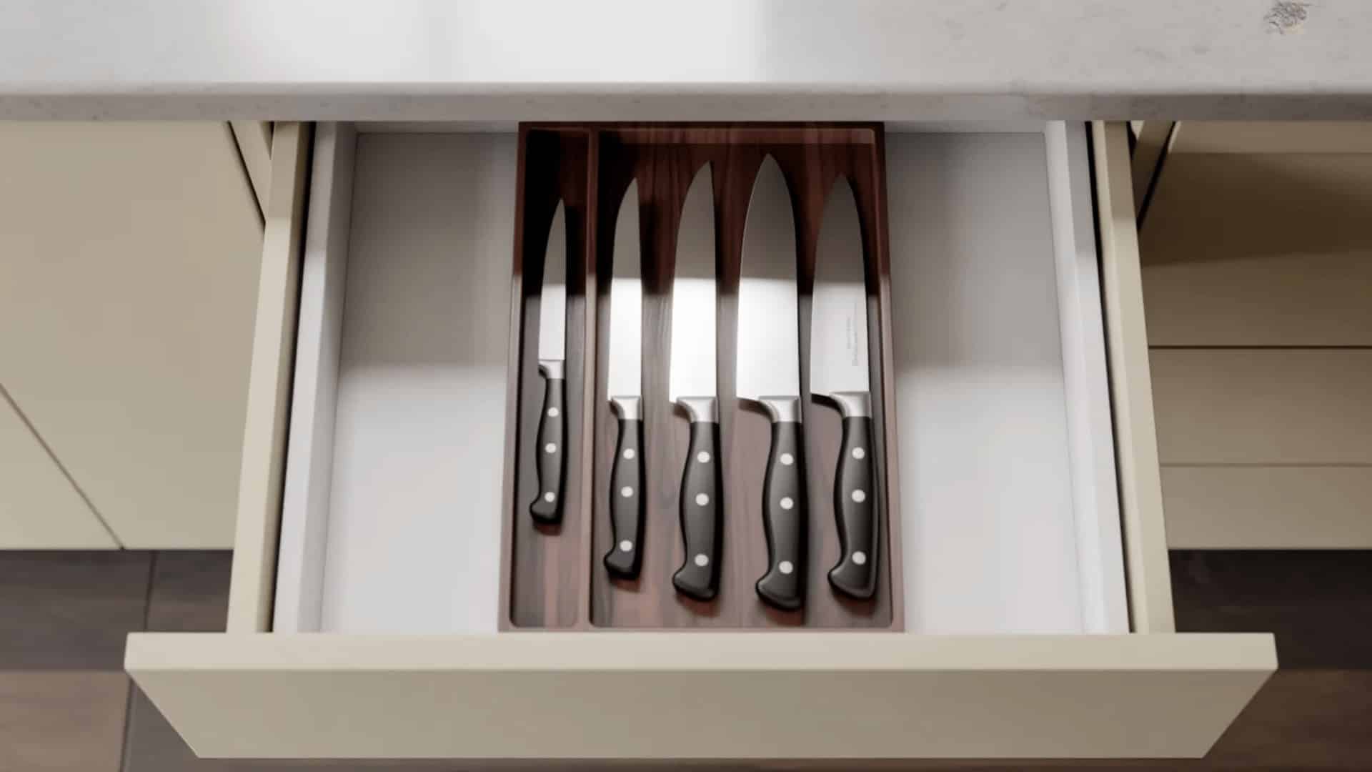 open kitchen drawer with dark wooden knife block insert holding five kitchen knives securely in individual labeled slots