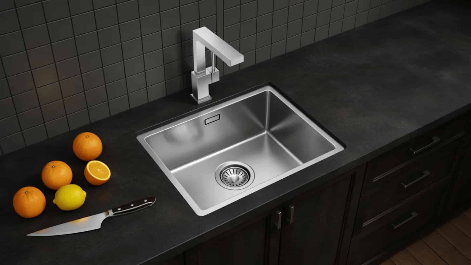 square stainless steel flush mount sink level with black granite countertop, angular chrome faucet and dark gray tile backsplash
