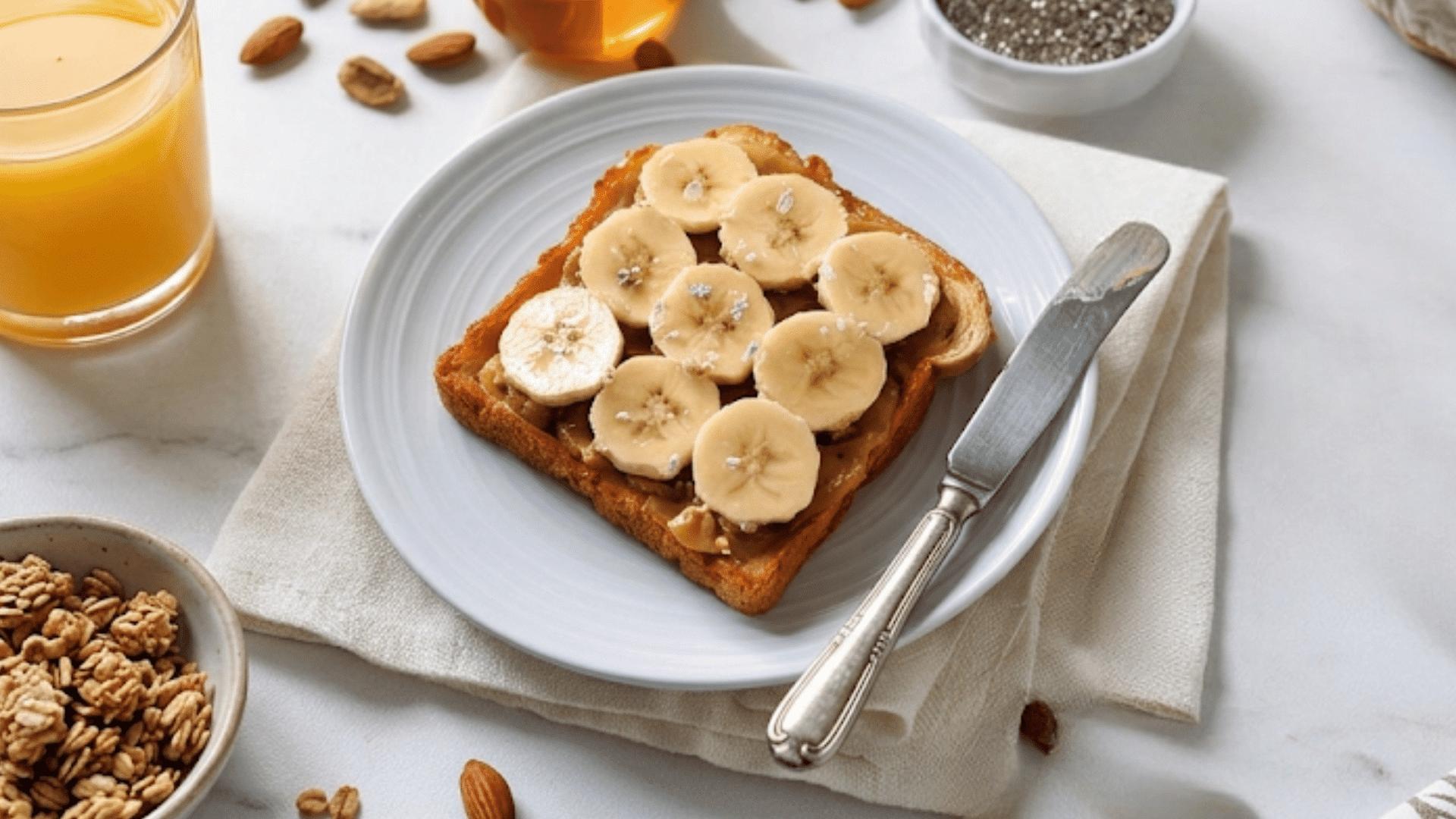 a slice of toast topped with banana slices and almond butter on a plate