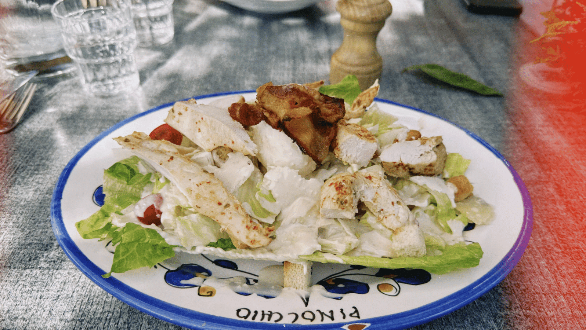 chicken caesar salad with lettuce pieces grilled chicken and creamy dressing on plate