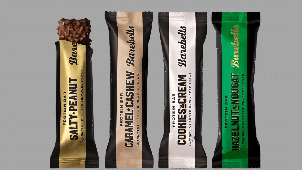 comparison of barebells protein bars in salty peanut caramel cashew cookies and cream and hazelnut nougat flavors in colorful packaging
