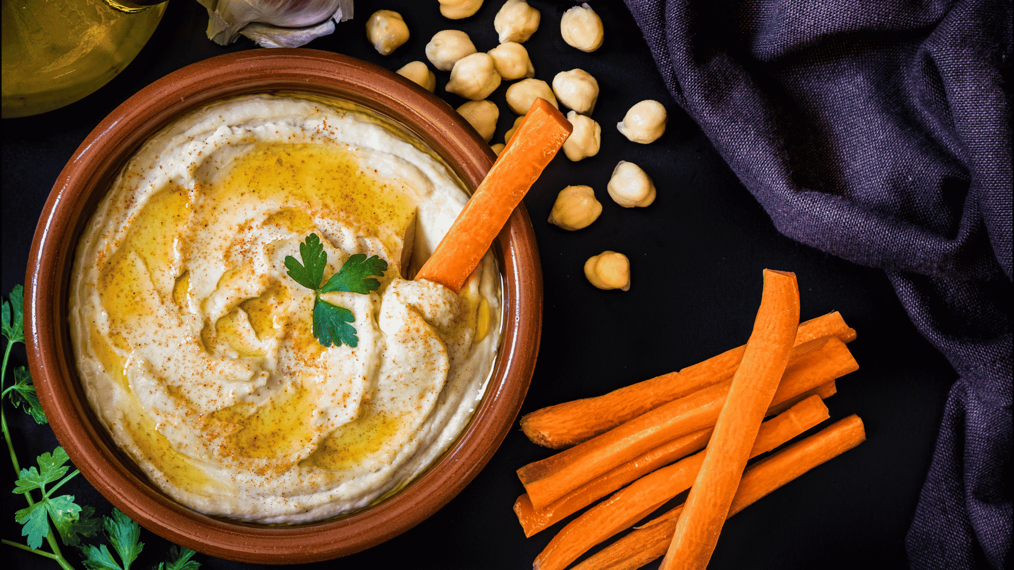 creamy hummus bowl served with fresh vegetables and colorful ingredients on a rustic table setting