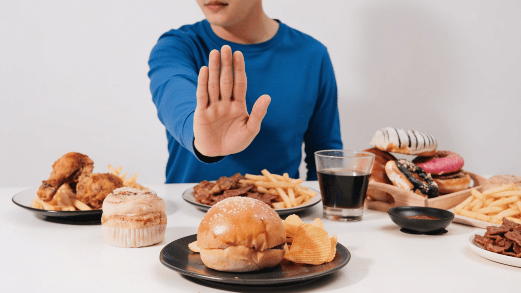 person avoiding common acid reflux trigger foods including burger fries fried chicken pastries processed meat and soda