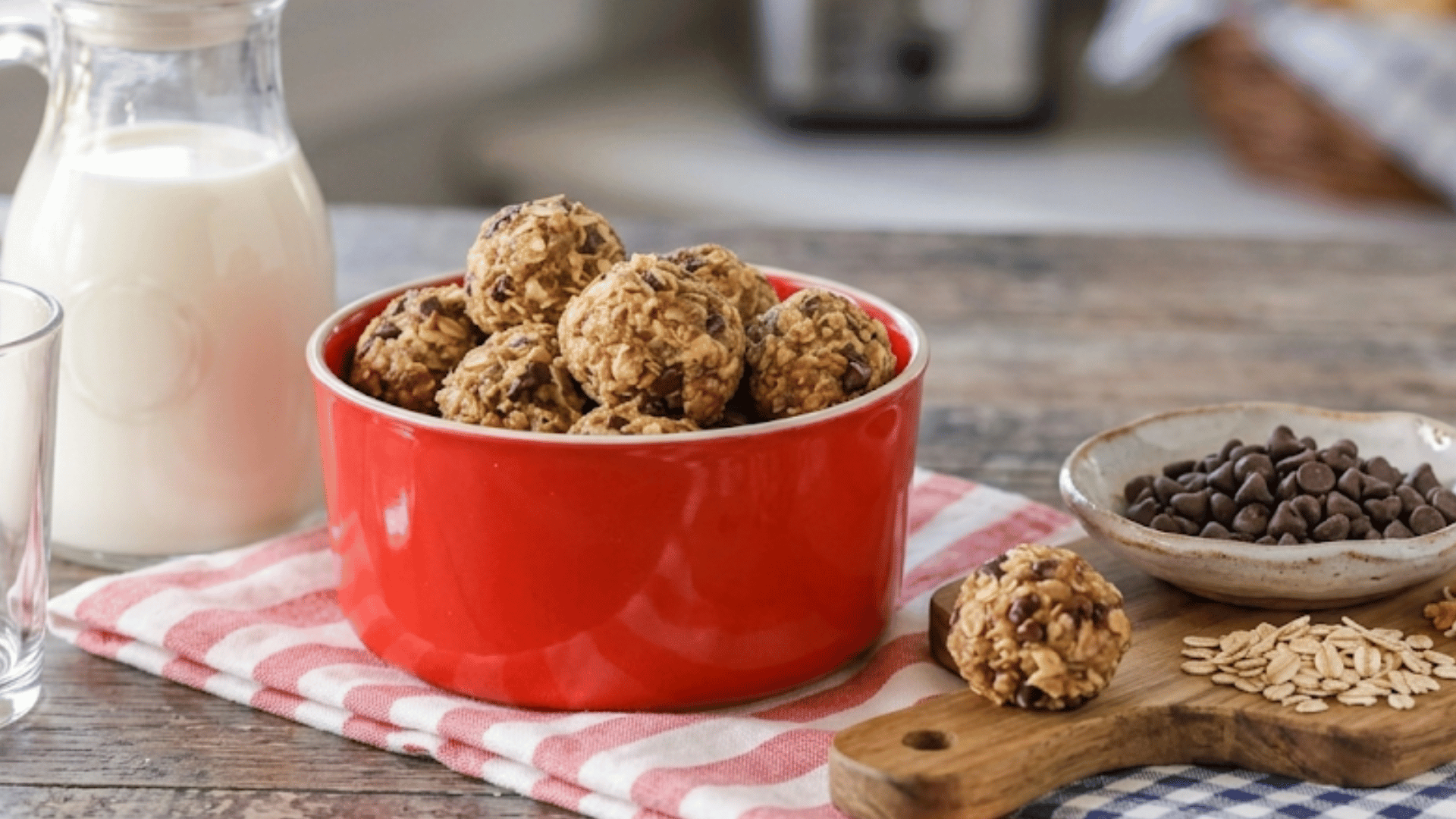 red bowl filled with oat energy bites made with oats chocolate chips and seeds served on checkered cloth for healthy snack