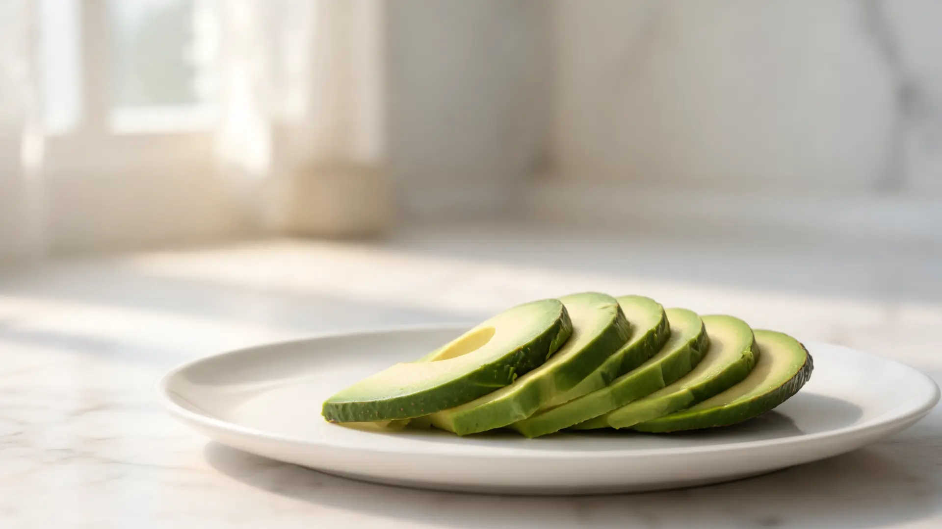 sliced avocado arranged on a clean plate with soft natural light and minimal background