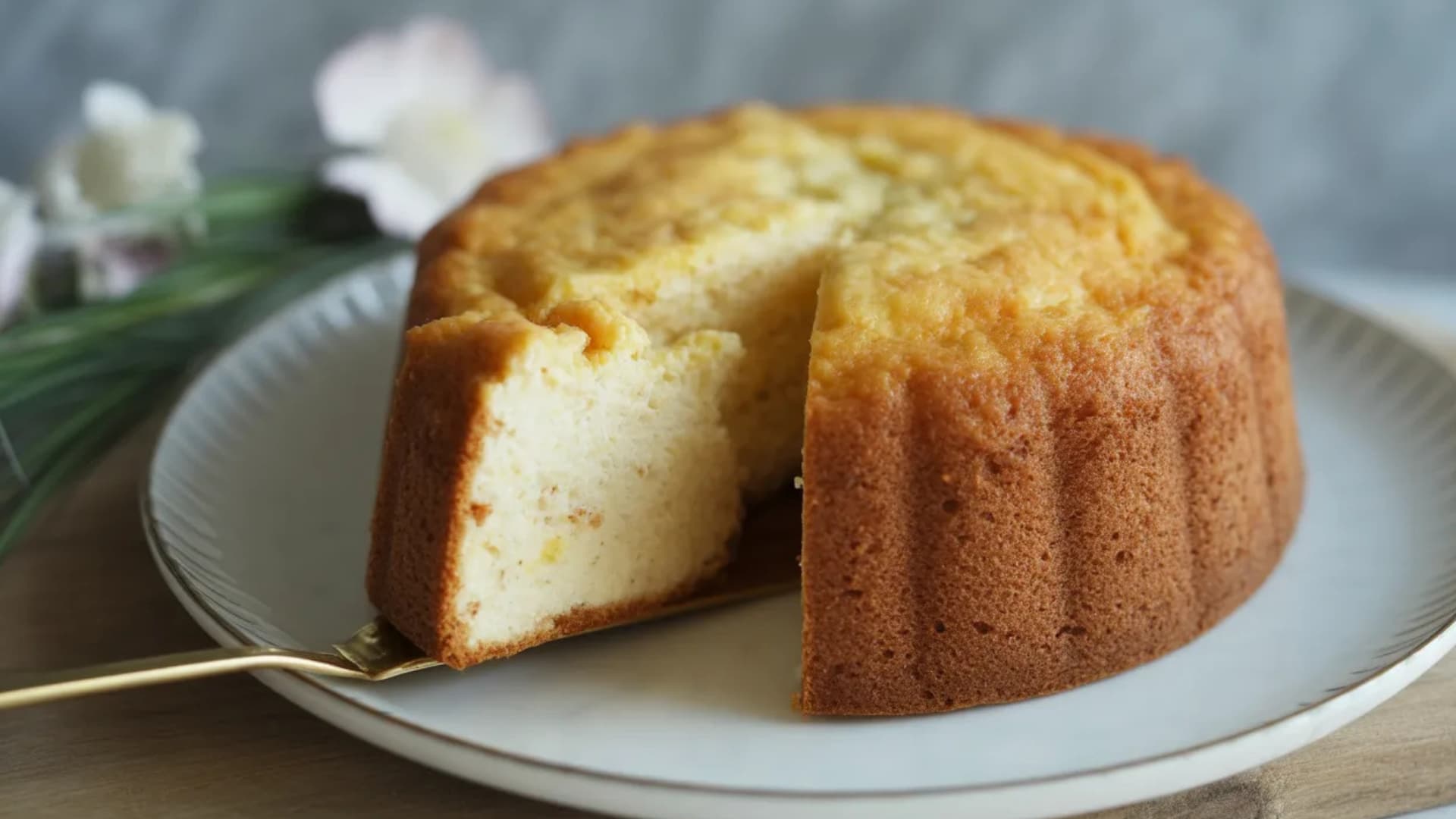 soft ricotta sponge cake with golden crust and airy interior served on plate with slice removed