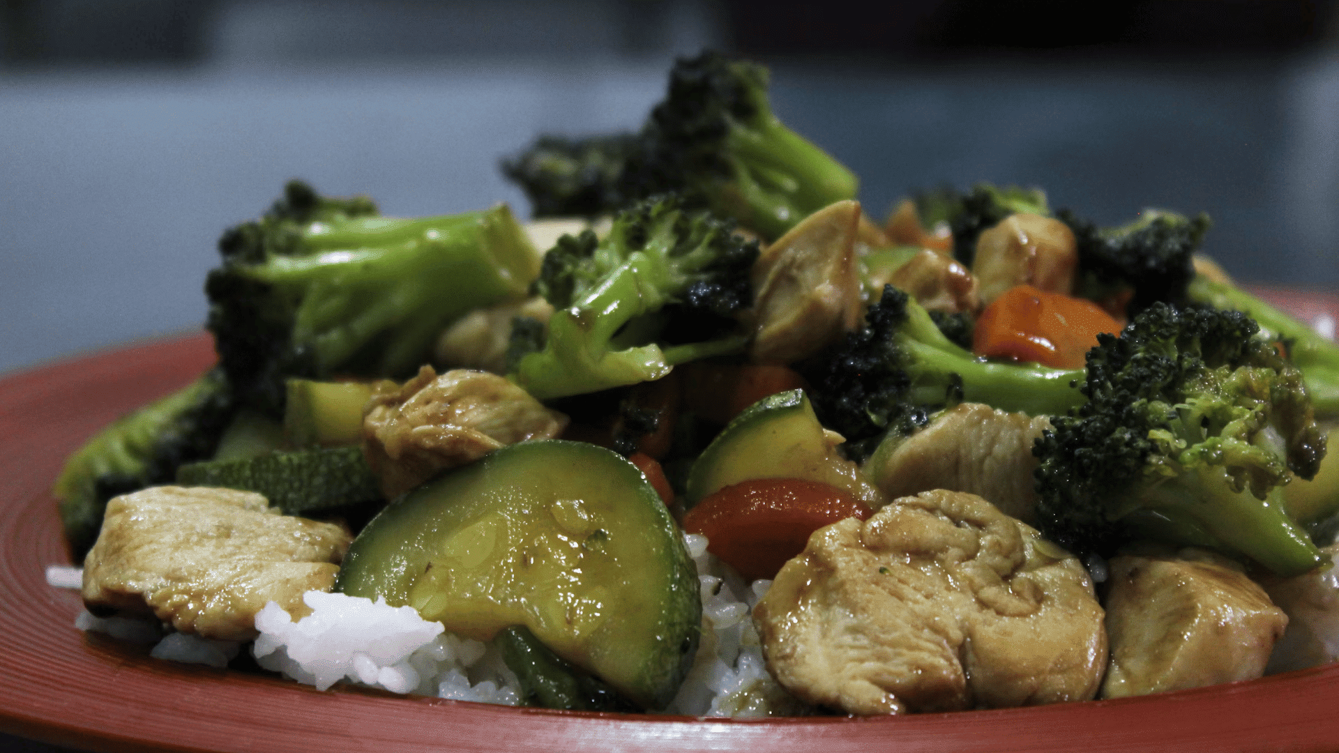 stir fried chicken with broccoli zucchini and vegetables served over white rice