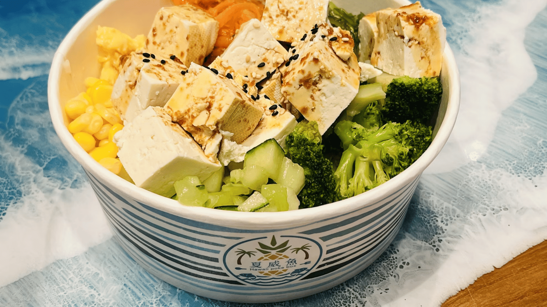 tofu bowl with broccoli corn cucumber and carrots topped with sesame seeds