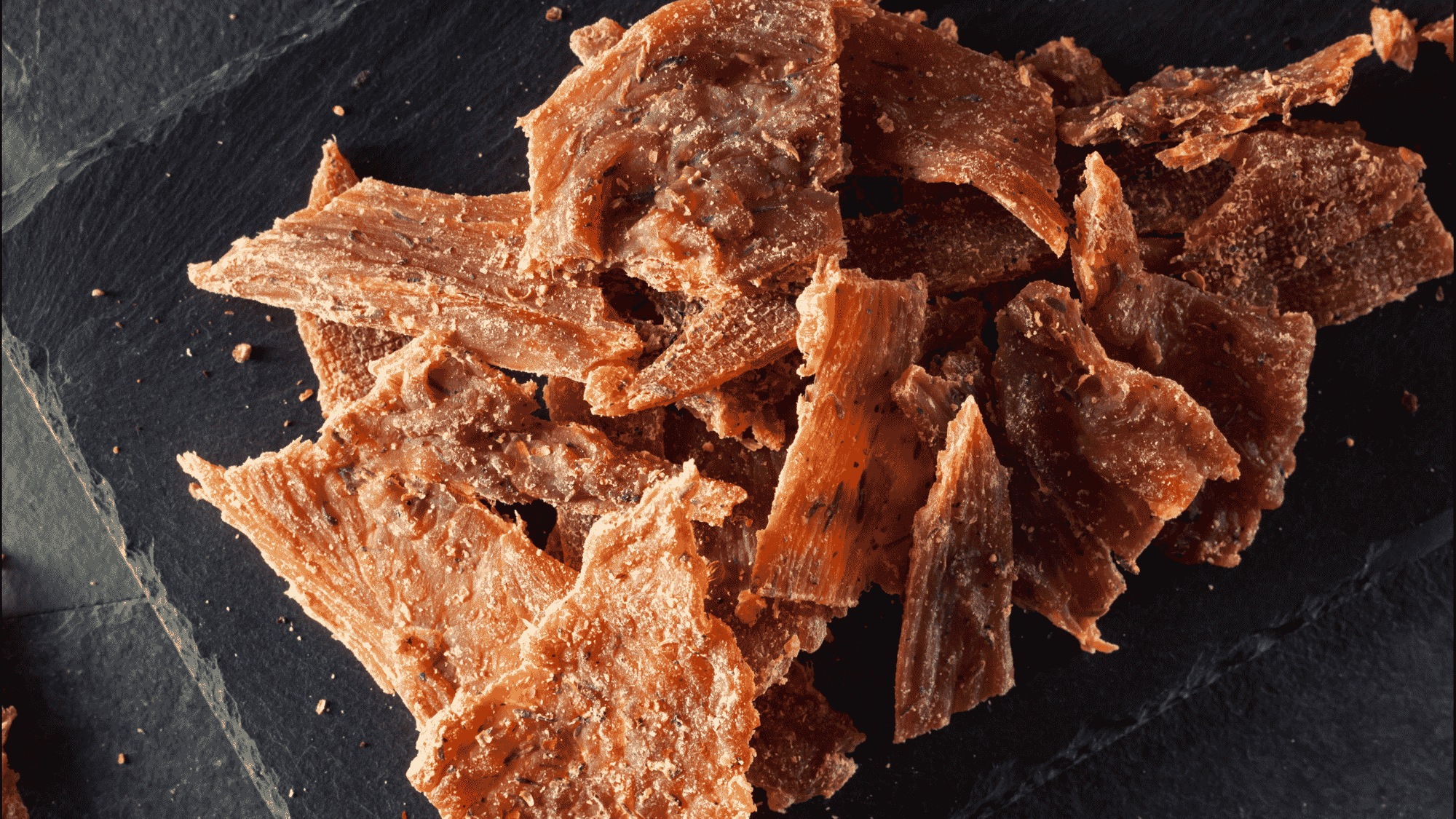 turkey and beef protein snack pieces with crispy texture arranged on dark surface for a savory bite