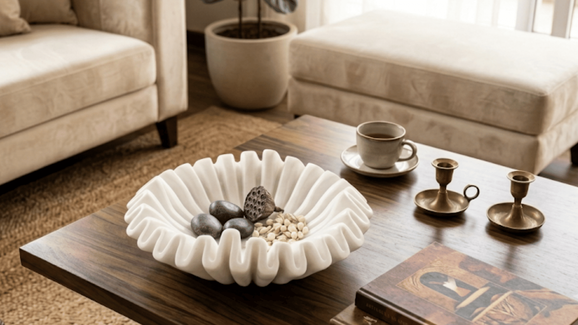 white decorative bowl with stones and dried botanicals on a wooden coffee table in a bright living room
