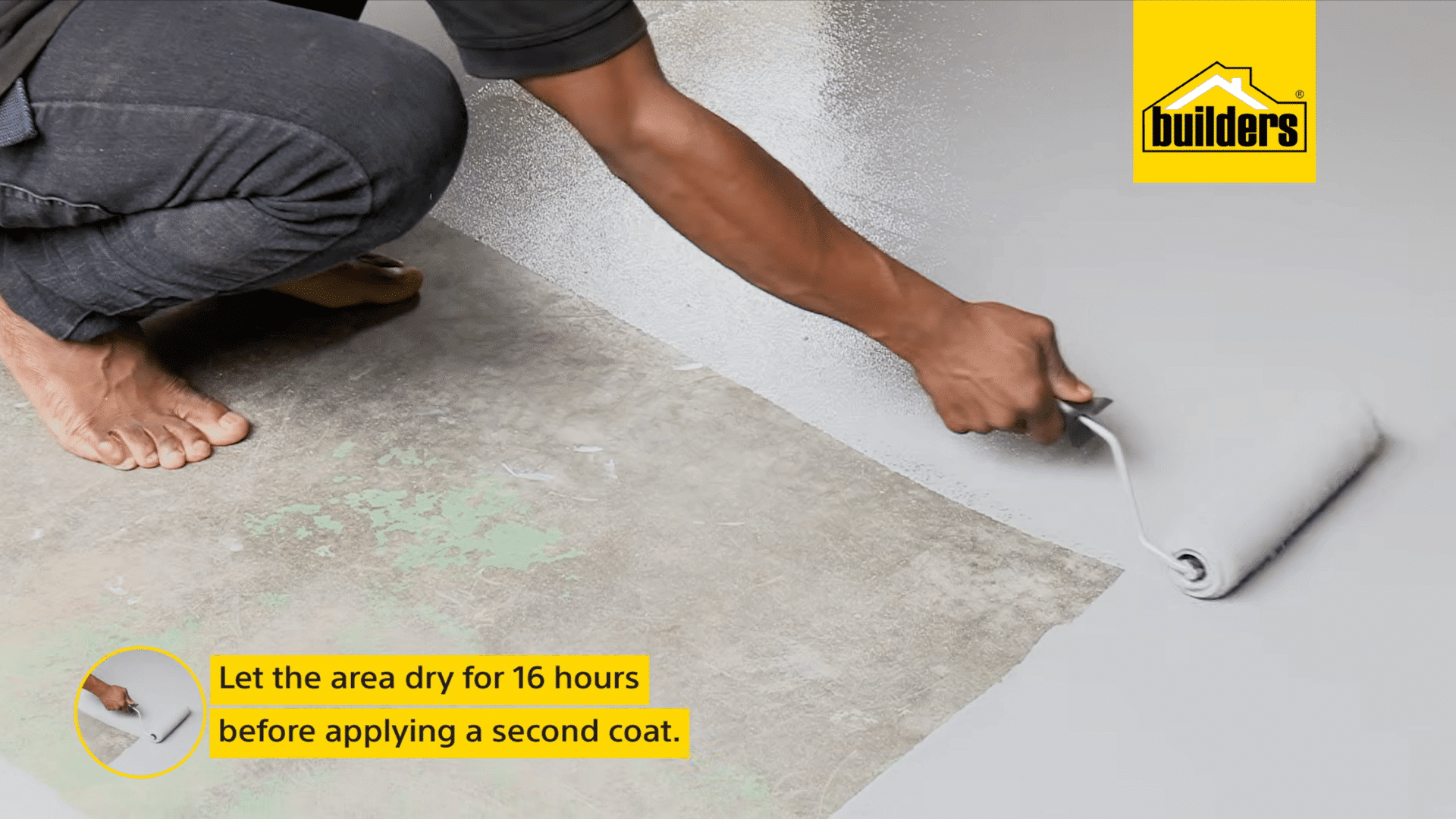 a person applies a second coat of grey floor paint with a roller after allowing the first coat to dry for the recommended time