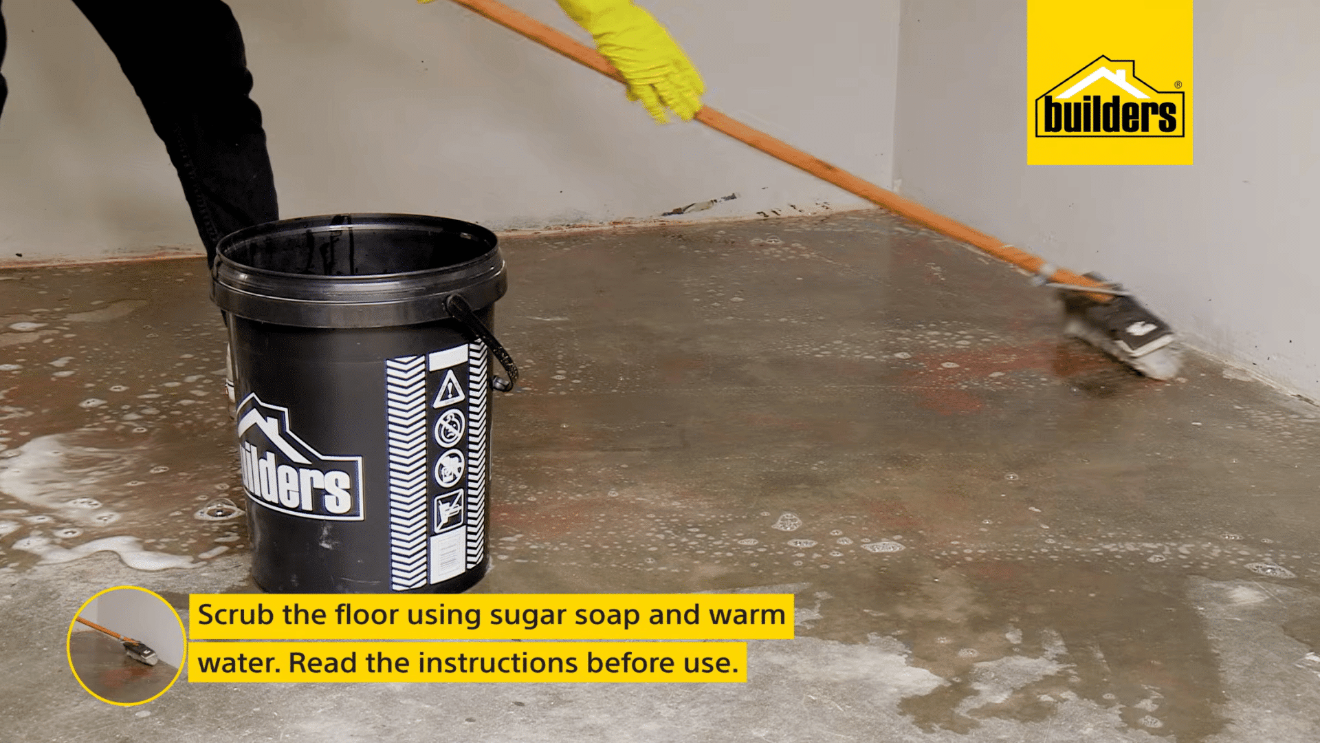 a person scrubs a concrete floor with sugar soap and warm water to clean the surface before applying fresh floor paint