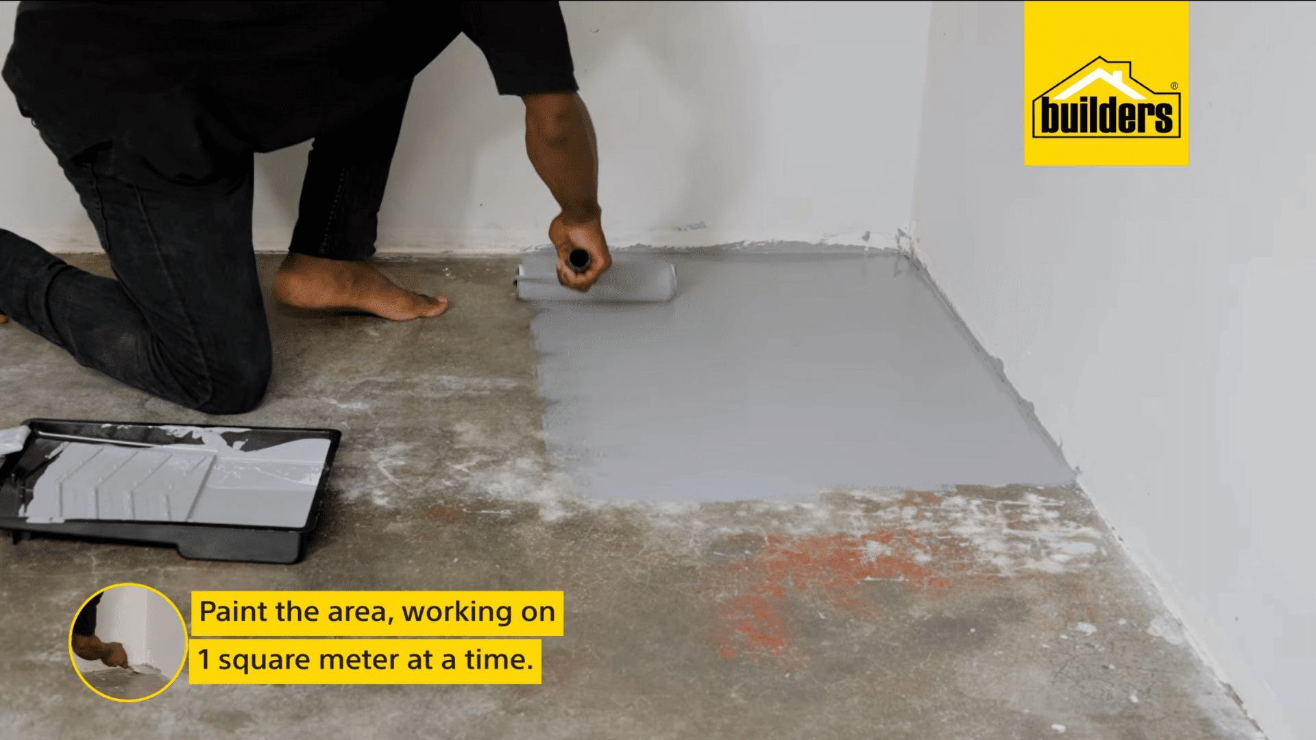 a person uses a paint roller to apply grey floor paint in small sections across a prepared concrete surface for an even finish