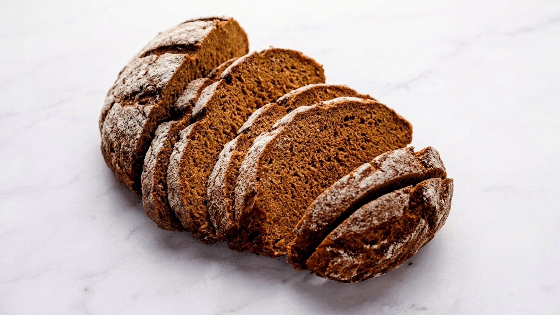 sliced rye bread loaf showing dense texture and wholesome grain appearance on a wooden surface with rustic presentation