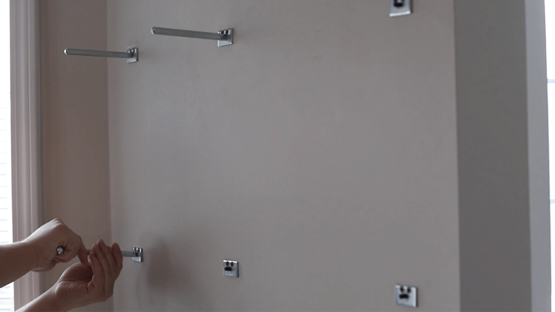 wooden shelf pressed against wall mounting posts to mark accurate drilling locations in the back