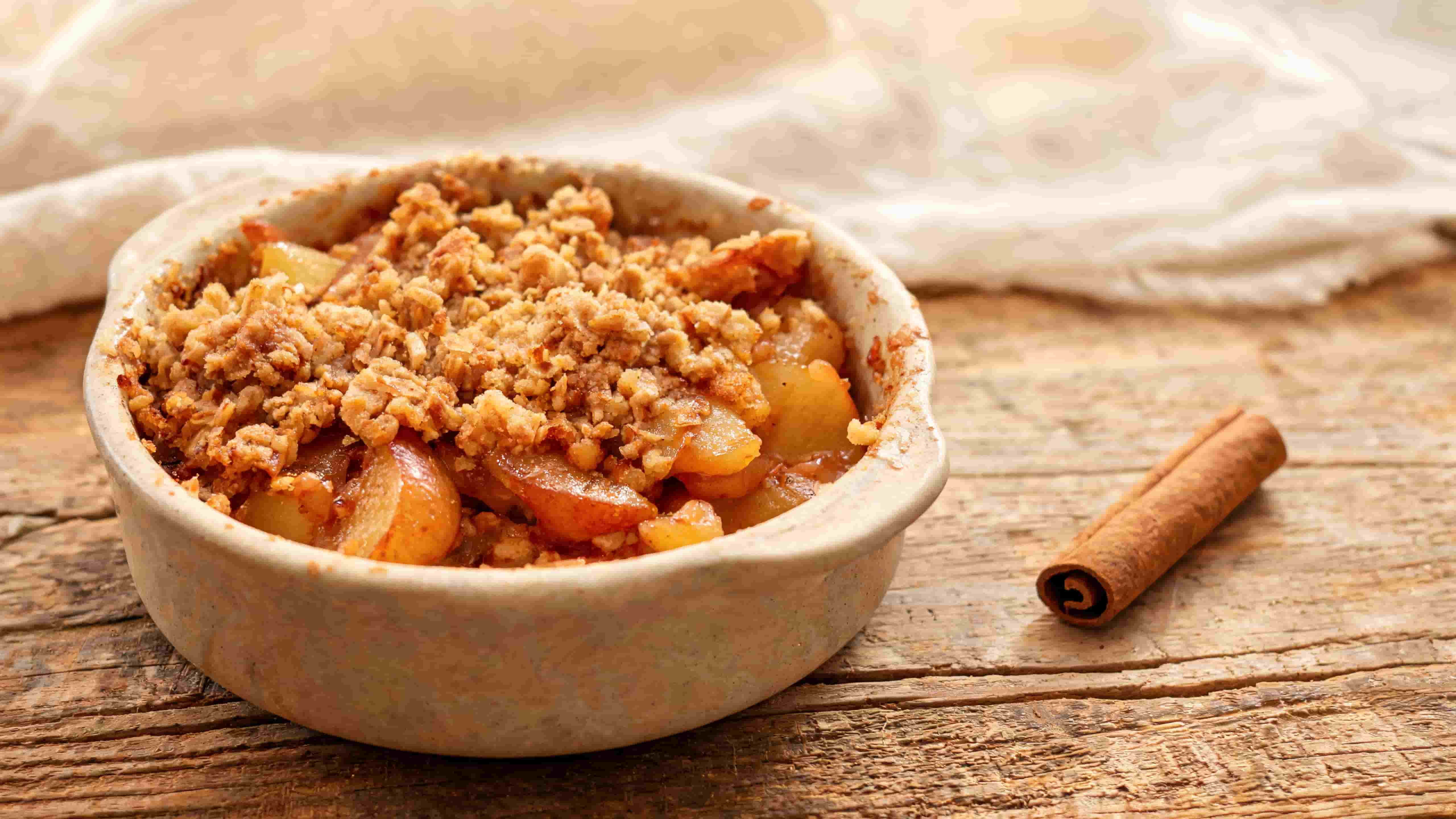 baked apple crisp with cinnamon spiced apples and a golden crumb topping in a rustic dish