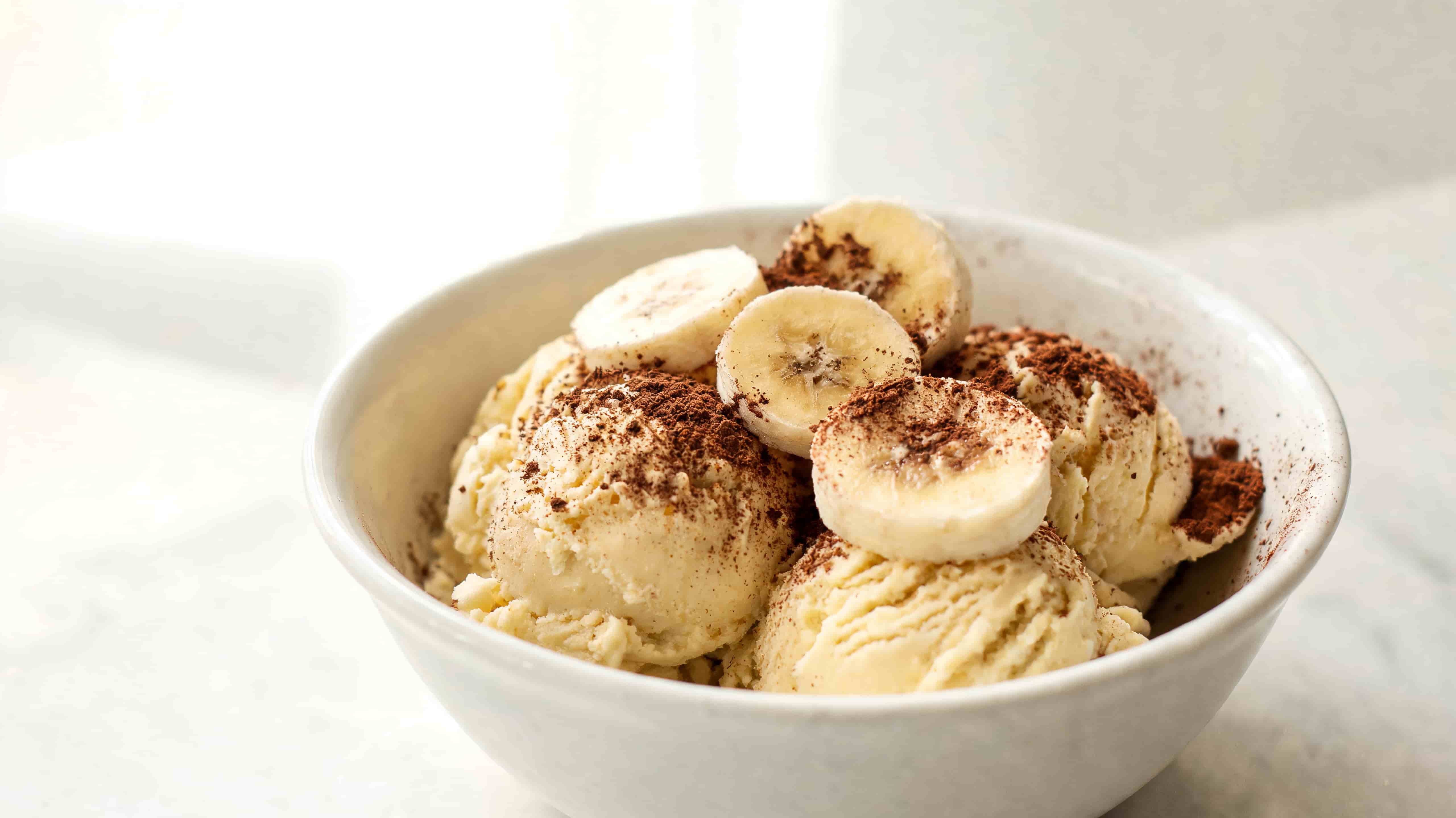 banana ice cream topped with sliced banana and a dusting of cinnamon for a simple creamy dessert