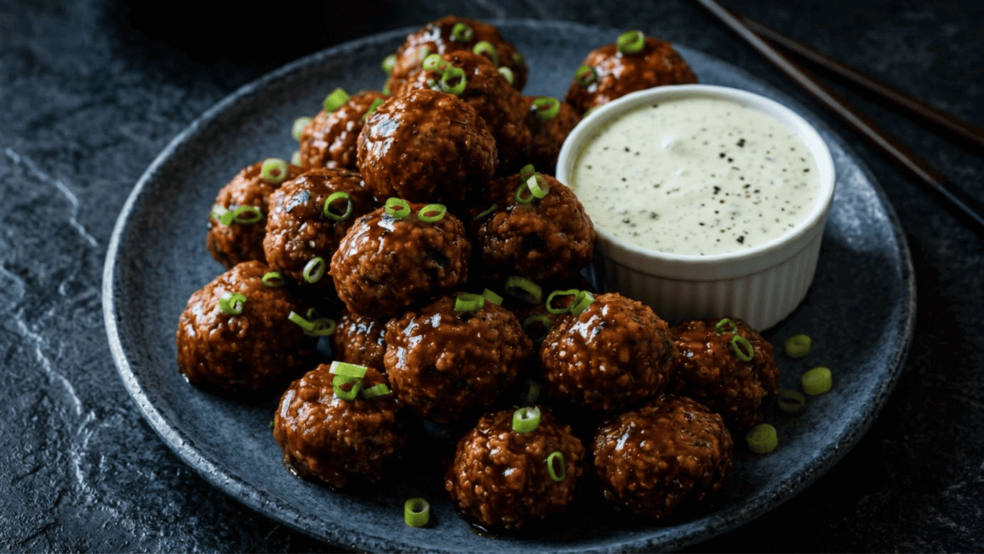 buffalo chicken meatballs topped with green onions and served with a creamy dipping sauce