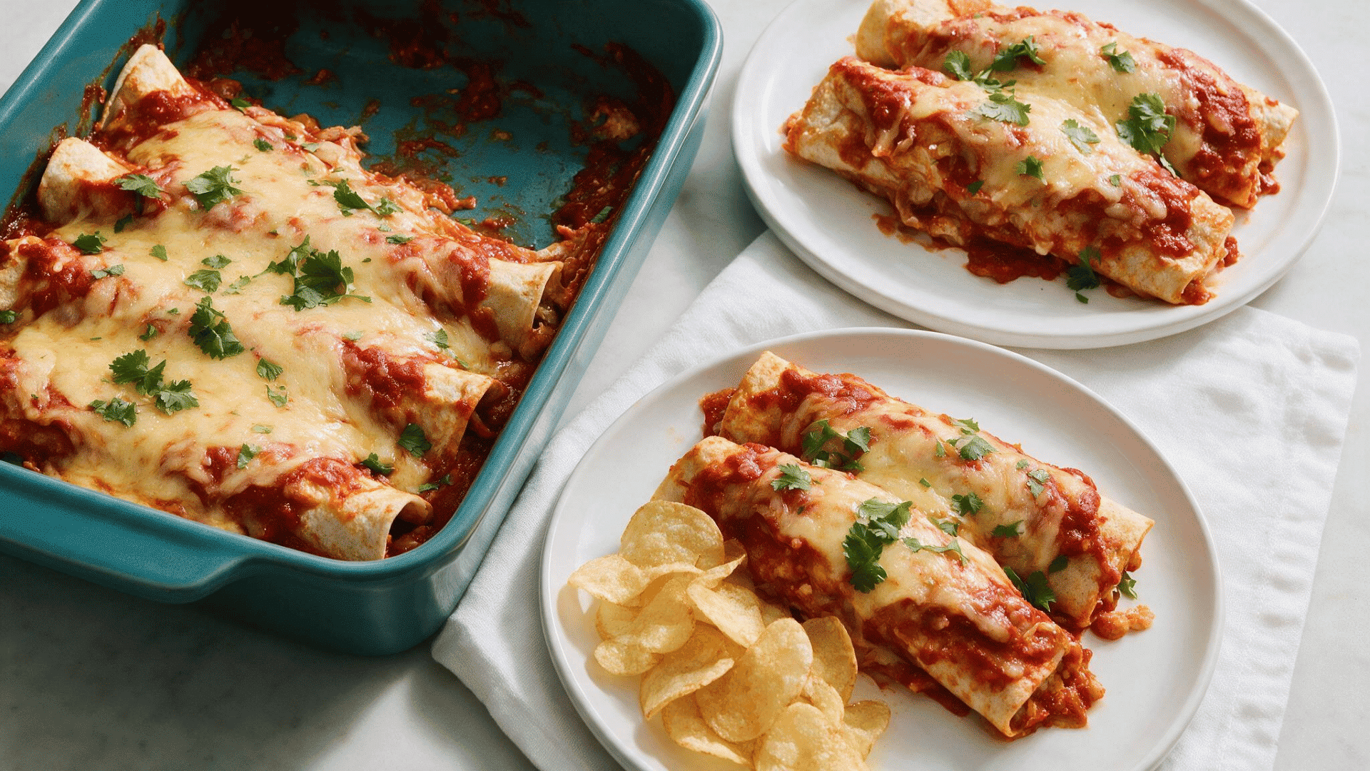 ground chicken enchiladas covered with red sauce melted cheese and fresh cilantro served with potato chips