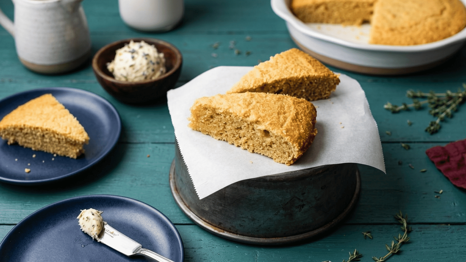 golden keto cornbread slices served with herb butter on a teal table for a simple low carb side dish